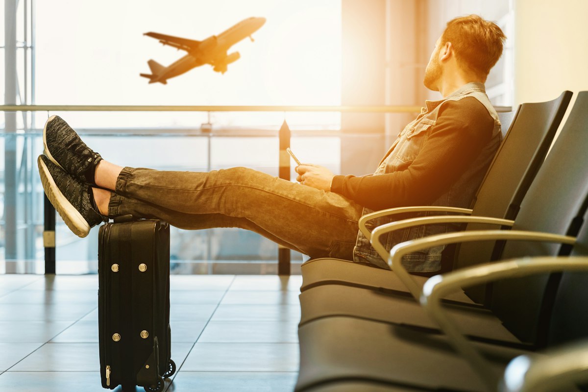 Viajero esperando en el aeropuerto mientras despega un avión